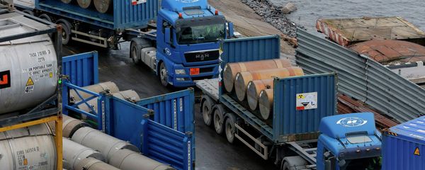 Trucks carrying containers with uranium to be used as fuel for nuclear reactors line up for loading them, on a port in St. Petersburg, Russia, Thursday, Nov. 14, 2013 - Sputnik International