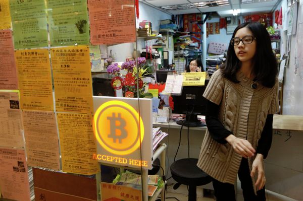 A staff member from a travel agency displays a Bitcoin logo as they accept bitcoins for payment in Hong Kong Friday, Feb. 28, 2014, after the world's first bitcoin retail store opened in Hong Kong, despite the virtual currency facing much scrutiny. A staff member from a travel agency displays a Bitcoin logo as they accept bitcoins for payment in Hong Kong Friday, Feb. 28, 2014, after the world's first bitcoin retail store opened in Hong Kong, despite the virtual currency facing much scrutiny. - Sputnik International