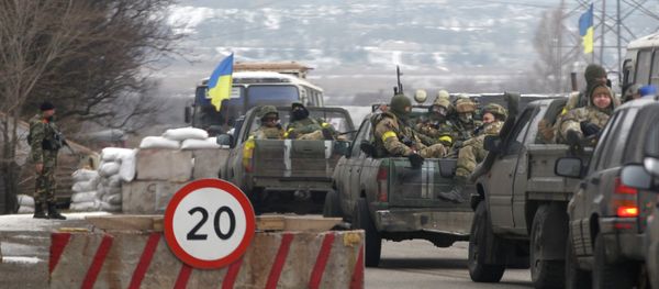 Ukrainian government troops sit in the back of pick-up trucks as they pass a checkpoint near the town of Mariupol, Ukraine - Sputnik International