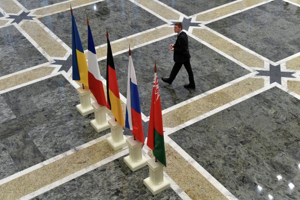 A man walks close to the flags on France, Russia, Germany, Ukraine and Belarus at the presidential residence in Minsk on February 11, 2015 A man walks close to the flags on France, Russia, Germany, Ukraine and Belarus at the presidential residence in Minsk on February 11, 2015 - Sputnik International