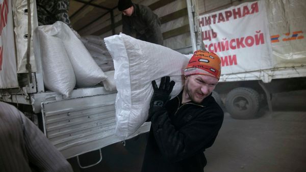 A man carries a sack of flour from a truck, that is part of a Russian humanitarian convoy delivering food, in Donetsk, February 15, 2015 - Sputnik International