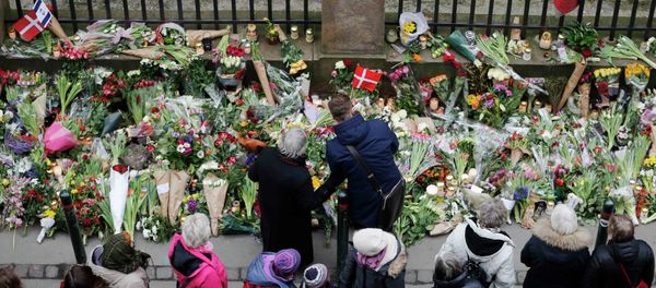 People pause for a moment of silence at a memorial site for the victims of the deadly attacks in front of the synagogue in Krystalgade in Copenhagen, February 16, 2015 - Sputnik International