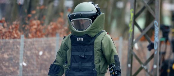 A bomb disposal expert makes his way to investigate an unattended package in front of a cafe in Oesterbro, Copenhagen February 17, 2015 - Sputnik International