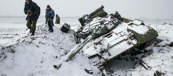 Members of the self-proclaimed Donetsk People's Republic army collect parts of a destroyed Ukrainian army tank in the town of Vuhlehirsk, about 10 km (6 miles) to the west of Debaltseve, February 16, 2015 - Sputnik International