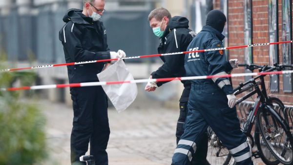 Danish police investigate the area where an unattended package was found in front of a cafe in Oesterbro, Copenhagen February 17, 2015 - Sputnik International