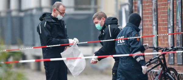 Danish police investigate the area where an unattended package was found in front of a cafe in Oesterbro, Copenhagen February 17, 2015 - Sputnik International