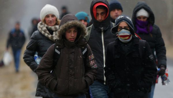 A group of Kosovars walk along a road after having illegally crossed the Hungarian-Serbian border near the village of Asotthalom February 6, 2015 - Sputnik International