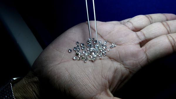 In this photograph taken on December 5, 2014, an Indian supervisor looks at the finished diamonds on a production line at a processing centre in Surat, some 265kms. south of Ahmedabad - Sputnik International