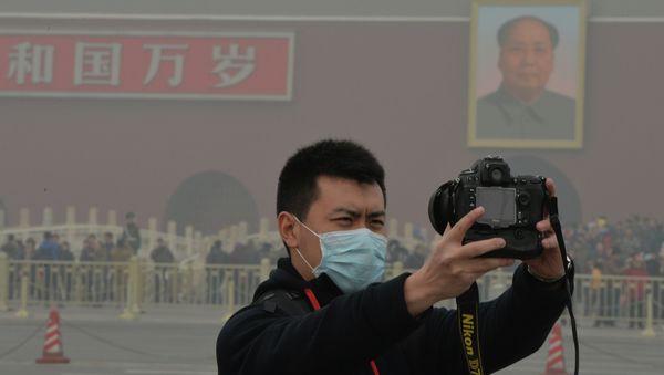 A Chinese tourists takes a photo while wearing a face mask in Tiananmen Square as heavy air pollution continues to shroud Beijing on February 26, 2014 A Chinese tourists takes a photo while wearing a face mask in Tiananmen Square as heavy air pollution continues to shroud Beijing on February 26, 2014 - Sputnik International