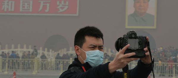 A Chinese tourists takes a photo while wearing a face mask in Tiananmen Square as heavy air pollution continues to shroud Beijing on February 26, 2014 A Chinese tourists takes a photo while wearing a face mask in Tiananmen Square as heavy air pollution continues to shroud Beijing on February 26, 2014 - Sputnik International