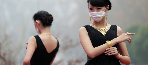 This picture taken on December 7, 2013 shows models wearing surgical masks as they parade a collection of gold jewelleries at a park in Nanjing, east China's Jiangsu province This picture taken on December 7, 2013 shows models wearing surgical masks as they parade a collection of gold jewelleries at a park in Nanjing, east China's Jiangsu province - Sputnik International