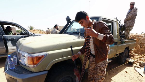 Fighters from the Fajr Libya (Libya Dawn) militia hold a position during clashes with forces loyal to Libya's internationally recognised government as they fight for the control of the area near the Wetia military air base on February 4, 2015 in al-Aqrabiyah, some 170 kilometres west of the capital Tripoli - Sputnik International