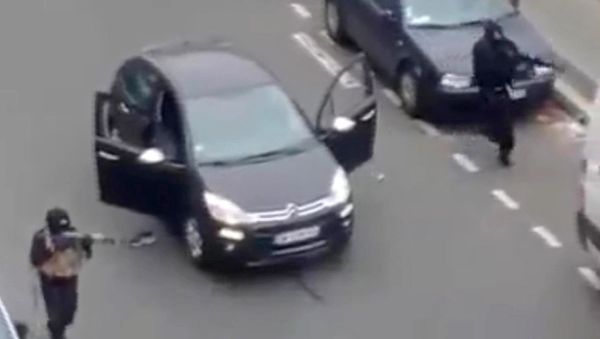 In this Wednesday Jan. 7, 2015, file photo, masked gunman fire their weapons outside the French satirical newspaper Charlie Hebdo's office in Paris - Sputnik International
