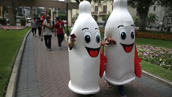 Two women dressed as condoms walk during an awareness program on International Condom Day in Lima, Peru. Two women dressed as condoms walk during an awareness program on International Condom Day in Lima, Peru. - Sputnik International