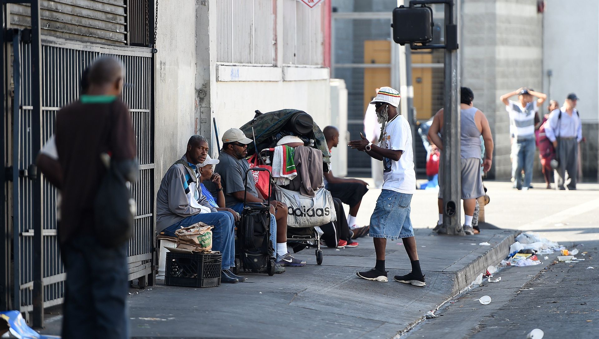 Men sit along a street in Skid Row in Los Angeles, California Men sit along a street in Skid Row in Los Angeles, California - Sputnik International, 1920, 25.02.2021