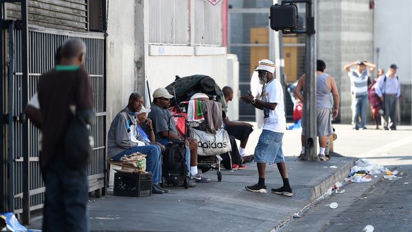 Men sit along a street in Skid Row in Los Angeles, California - Sputnik International