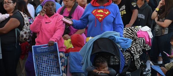 Mothers and their children wait for new shoes and school supplies during a charity event in Los Angeles Mothers and their children wait for new shoes and school supplies during a charity event in Los Angeles - Sputnik International
