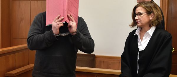 The former nurse identified only as Niels H. hides his face behind a folder while arriving in the courtroom beside his lawyer, Ulrike Baumann, in Oldenburg, Germany. - Sputnik International