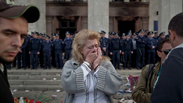 A woman cries back dropped by police troops guarding the burnt trade union building in Odessa, Ukraine, Saturday, May 3, 2014, where more than 30 people died trying to escape during clashes the day before A woman cries back dropped by police troops guarding the burnt trade union building in Odessa, Ukraine, Saturday, May 3, 2014, where more than 30 people died trying to escape during clashes the day before - Sputnik International