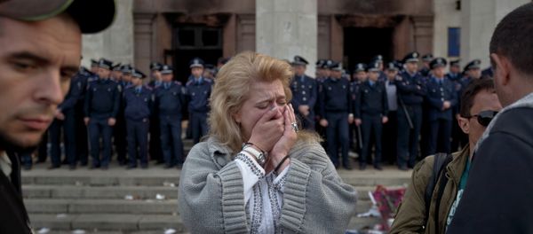 A woman cries back dropped by police troops guarding the burnt trade union building in Odessa, Ukraine, Saturday, May 3, 2014, where more than 30 people died trying to escape during clashes the day before A woman cries back dropped by police troops guarding the burnt trade union building in Odessa, Ukraine, Saturday, May 3, 2014, where more than 30 people died trying to escape during clashes the day before - Sputnik International