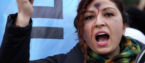 A woman with a bullet hole painted on her forehead takes part in a demonstration against the murder of 20-year-old Ozgecan Aslan. A woman with a bullet hole painted on her forehead takes part in a demonstration against the murder of 20-year-old Ozgecan Aslan. - Sputnik International