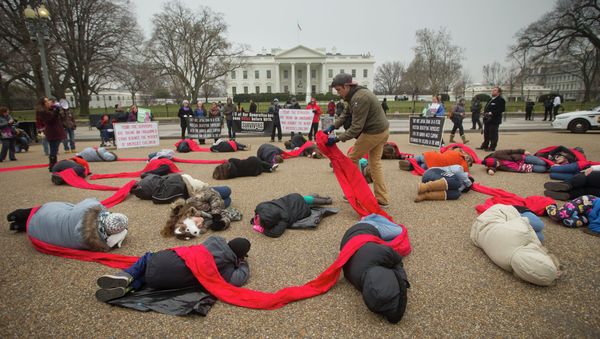 Anti-abortion activists are connected with a red piece of cloth as they stage a die-in in front of the White House. - Sputnik International