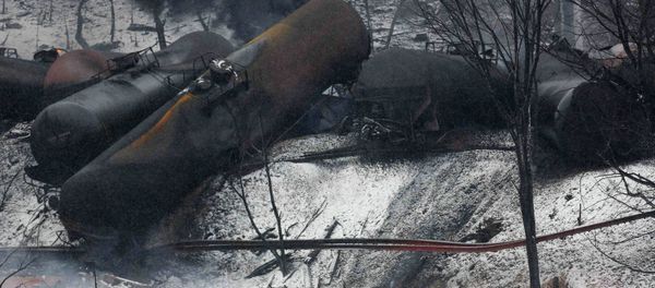 The charred remains of a house and a vehicle are shown below a derailed CSX Corp train in Mount Carbon, West Virginia The charred remains of a house and a vehicle are shown below a derailed CSX Corp train in Mount Carbon, West Virginia - Sputnik International