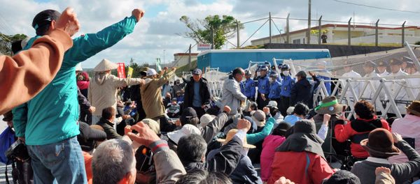 Anti-base activists raise their fists in front of a gate of the U.S. Marine Corps' Camp Schwab at the tiny hamlet of Henoko in Nago on the southern Japanese island of Okinawa, January 15, 2015 - Sputnik International