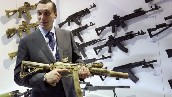 Aleksey Krivoruchko, chief executive of Russian firearms maker Kalashnikov Concern, holds a weapon during the International Defence Exhibition (IDEX) in Abu Dhabi February 22, 2015 - Sputnik International