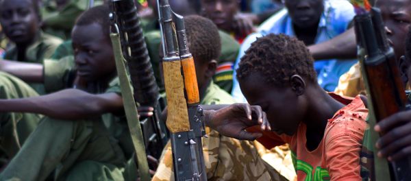 Children soldiers sit on February 10, 2015 with their rifles at a ceremony of the child soldiers disarmament, demobilisation and reintegration in South Sudan. Children soldiers sit on February 10, 2015 with their rifles at a ceremony of the child soldiers disarmament, demobilisation and reintegration in South Sudan. - Sputnik International