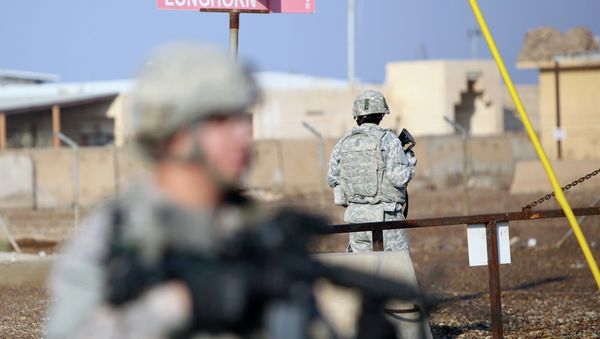 US soldiers stand guard at the Taji base complex which hosts Iraqi and US troops and is located thirty kilometres north of the capital Baghdad - Sputnik International