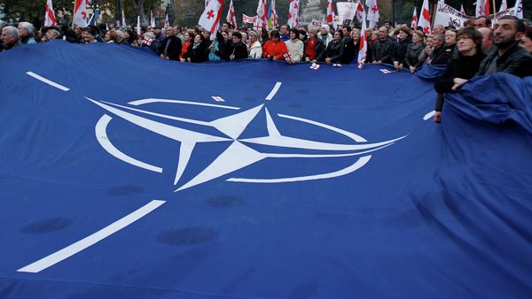 Demonstrators carry a huge banner with a NATO sign and Georgian national flags during a rally in Tbilisi Demonstrators carry a huge banner with a NATO sign and Georgian national flags during a rally in Tbilisi - Sputnik International
