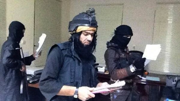 Shakir Waheib, a leader in the al-Qaida-linked Islamic State of Iraq and the Levant (ISIL), center, searching a government office in Ramadi, in Iraq's Anbar Province Shakir Waheib, a leader in the al-Qaida-linked Islamic State of Iraq and the Levant (ISIL), center, searching a government office in Ramadi, in Iraq's Anbar Province - Sputnik International