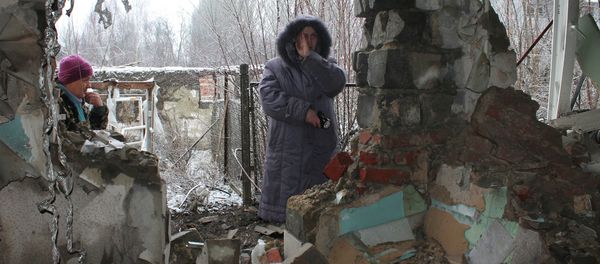 Local residents standing at what has remained of their house after another artillery shelling of Donetsk. - Sputnik International