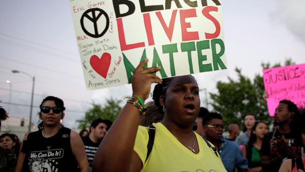 Desiree Griffiths, 31, of Miami, holds up a sign saying Black Lives Matter, with the names of Michael Brown and Eric Garner, two black men recently killed by police, during a protest Desiree Griffiths, 31, of Miami, holds up a sign saying Black Lives Matter, with the names of Michael Brown and Eric Garner, two black men recently killed by police, during a protest - Sputnik International