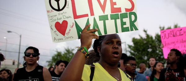 Desiree Griffiths, 31, of Miami, holds up a sign saying Black Lives Matter, with the names of Michael Brown and Eric Garner, two black men recently killed by police, during a protest Desiree Griffiths, 31, of Miami, holds up a sign saying Black Lives Matter, with the names of Michael Brown and Eric Garner, two black men recently killed by police, during a protest - Sputnik International