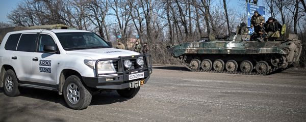 A car of Organization for Security and Co-operation in Europe (OSCE) mission drives past a Ukrainian military vehicle near Artemivsk, eastern Ukraine - Sputnik International
