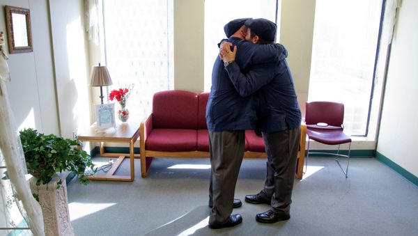 Charles Windham, left, 53, and Edgard Perez, 40, embrace after they were married at the marriage license bureau - Sputnik International