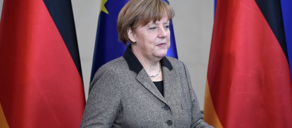 German Chancellor Angela Merkel holds the annual report of an indepenent commission of experts for research and innovation she was handed over - Sputnik International