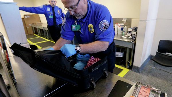 A TSA agent checks a bag at a security checkpoint area at Midway International Airport in Chicago. A TSA agent checks a bag at a security checkpoint area at Midway International Airport in Chicago. - Sputnik International