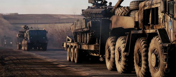 Military trucks from the Ukrainian armed forces transport tanks on the road near Artemivsk, eastern Ukraine, February 24, 2015 - Sputnik International