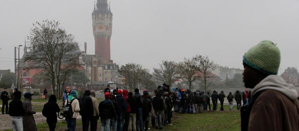 Migrants queue during a daily food distribution close to the city hall in Calais, northern France - Sputnik International