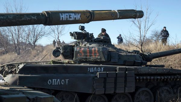 A tank crew member of the self-proclaimed Donetsk People's Republic Army sits on top of a tank at a checkpoint on the road from the town of Vuhlehirsk to Debaltseve - Sputnik International