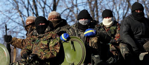 Ukrainian government soldiers sit on top of their vehicle driving on a road stretching away from the town of Artemivsk, Ukraine - Sputnik International