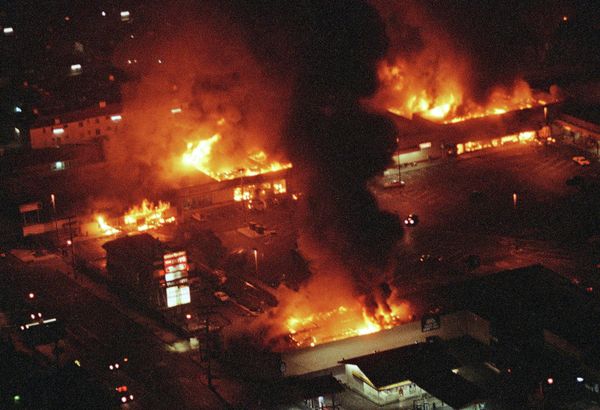 Several buildings in a Los Angeles shopping center fully engulfed in flames during the 1992 riots. - Sputnik International