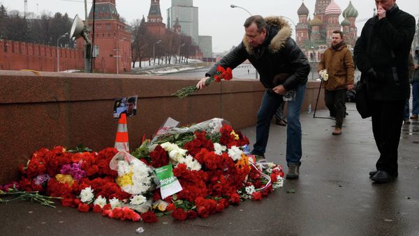 People come to lay flowers at the site, where Boris Nemtsov was shot dead, with St. Basil's Cathedral (R) and the Kremlin walls seen in the background, in central Moscow, February 28, 2015. People come to lay flowers at the site, where Boris Nemtsov was shot dead, with St. Basil's Cathedral (R) and the Kremlin walls seen in the background, in central Moscow, February 28, 2015. - Sputnik International