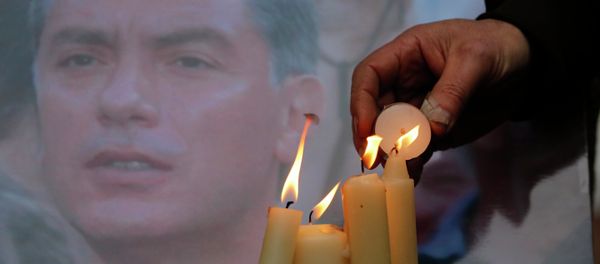 People light candles in memory of Boris Nemtsov, seen behind, at the monument of political prisoners 'Solovetsky Stone' in central St.Petersburg, Russia, Saturday, Feb. 28, 2015. People light candles in memory of Boris Nemtsov, seen behind, at the monument of political prisoners 'Solovetsky Stone' in central St.Petersburg, Russia, Saturday, Feb. 28, 2015. - Sputnik International