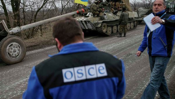 Members of Special Monitoring Mission of the Organization for Security and Cooperation (OSCE) to Ukraine walk along a convoy of Ukrainian armed forces in Paraskoviyvka, eastern Ukraine Members of Special Monitoring Mission of the Organization for Security and Cooperation (OSCE) to Ukraine walk along a convoy of Ukrainian armed forces in Paraskoviyvka, eastern Ukraine - Sputnik International