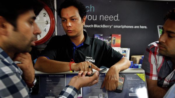 An Indian shopkeeper, center, tries to sell a Nokia mobile phone to a customer, left, in New Delhi, India - Sputnik International