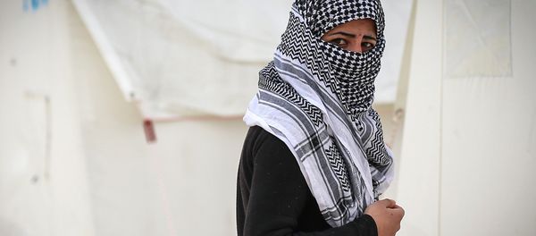 A Syrian refugee who fled violence in and around the Syrian city of Ayn al-Arab or Kobani walks in a camp recently opened by Turkey, in the border town of Suruc. - Sputnik International